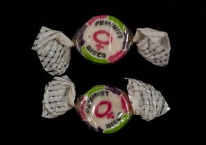two pieces of boiled sweets with writing wrapped in cellophane