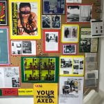 Photograph of pin board in showing many examples of photographic work and promotional materials from exhibitions and events