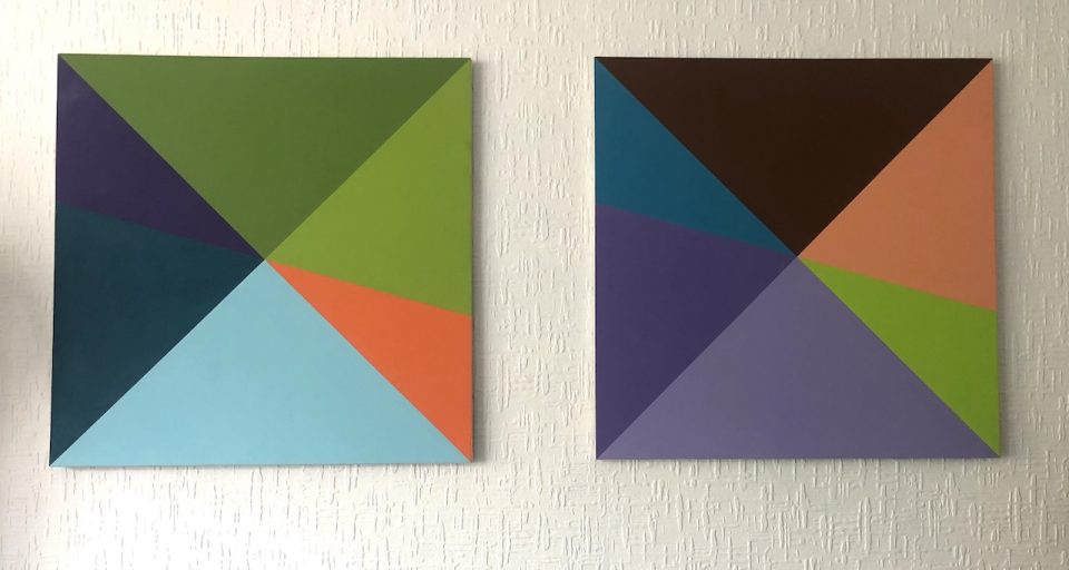 Two square canvases painted with colourful triangles