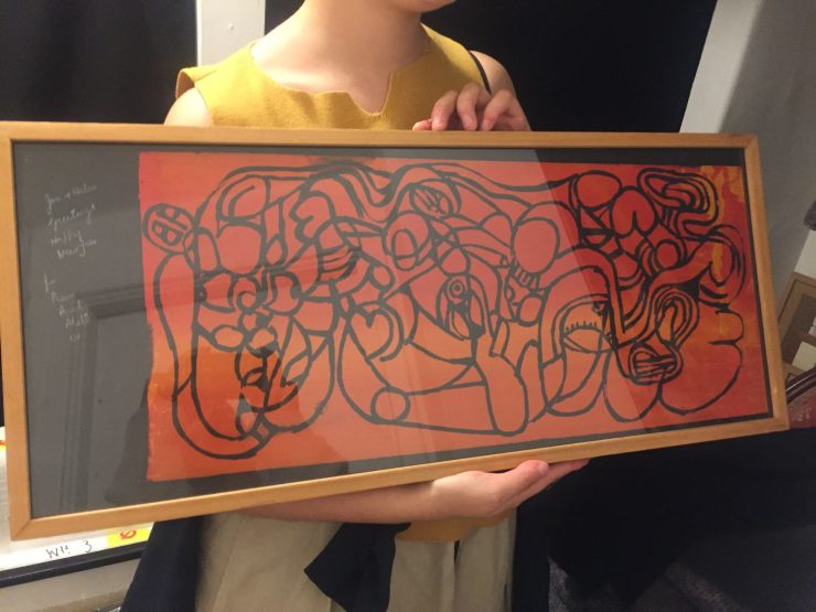 woman holding framed artwork by Prem Chandra