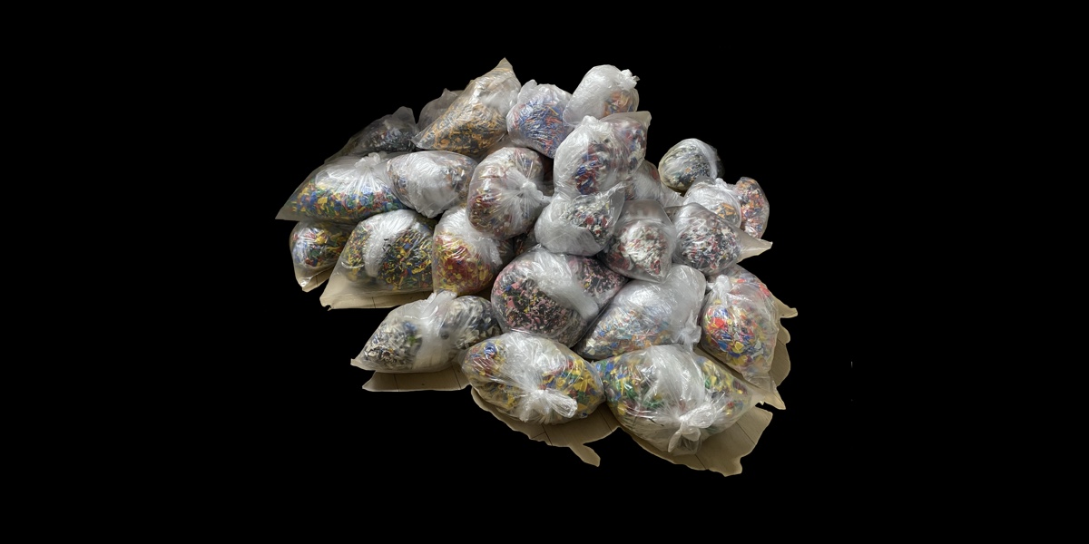 A picture of several bags of colourful objects against a black background.