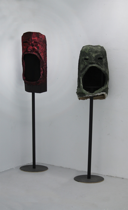 Two sculptures in the shape of faces used to decorate freestanding speakers.