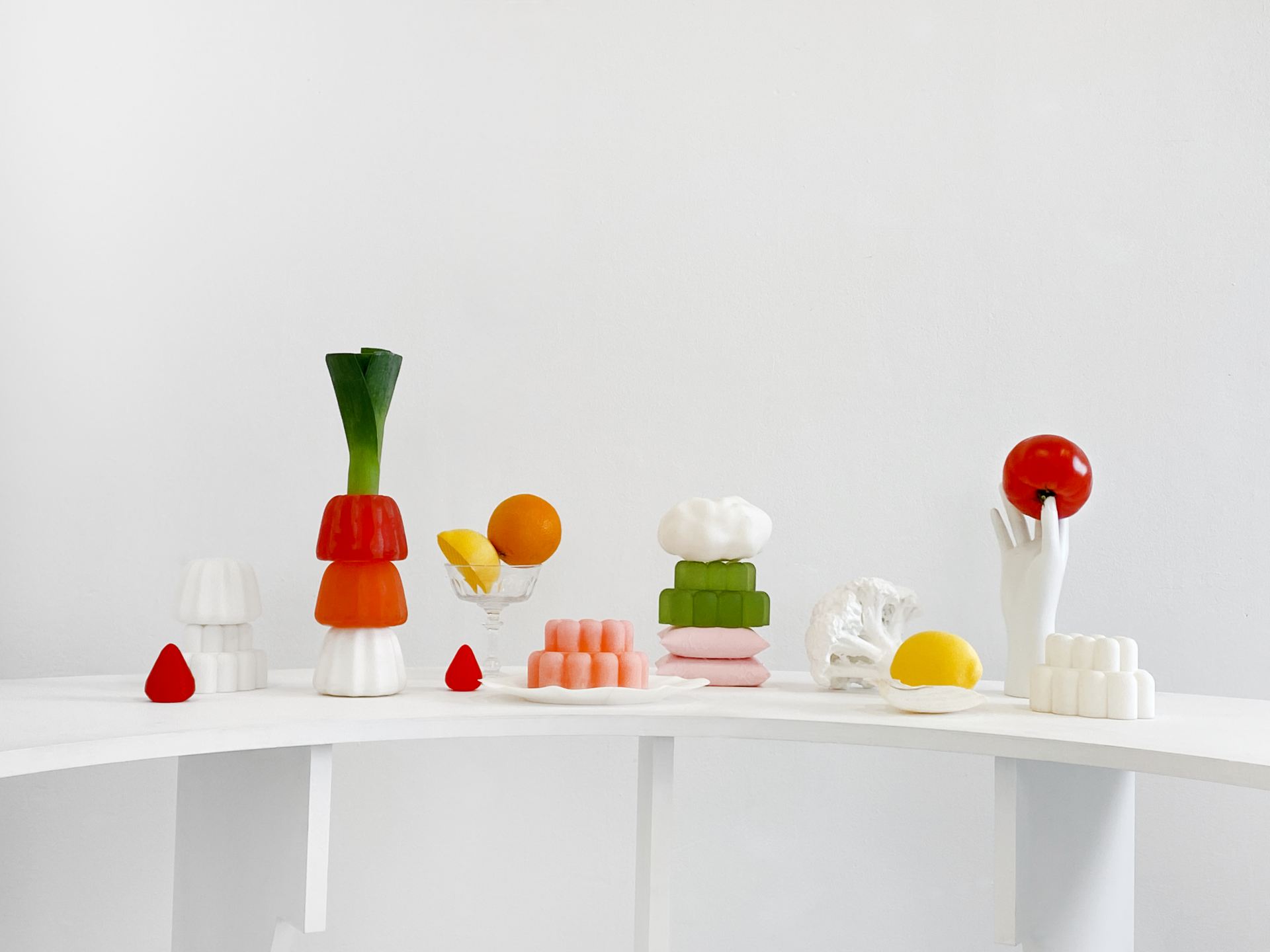 An image of several jelly-like resin objects in a scene with 3D Printed objects such as hands, other jellies and vegetables.
