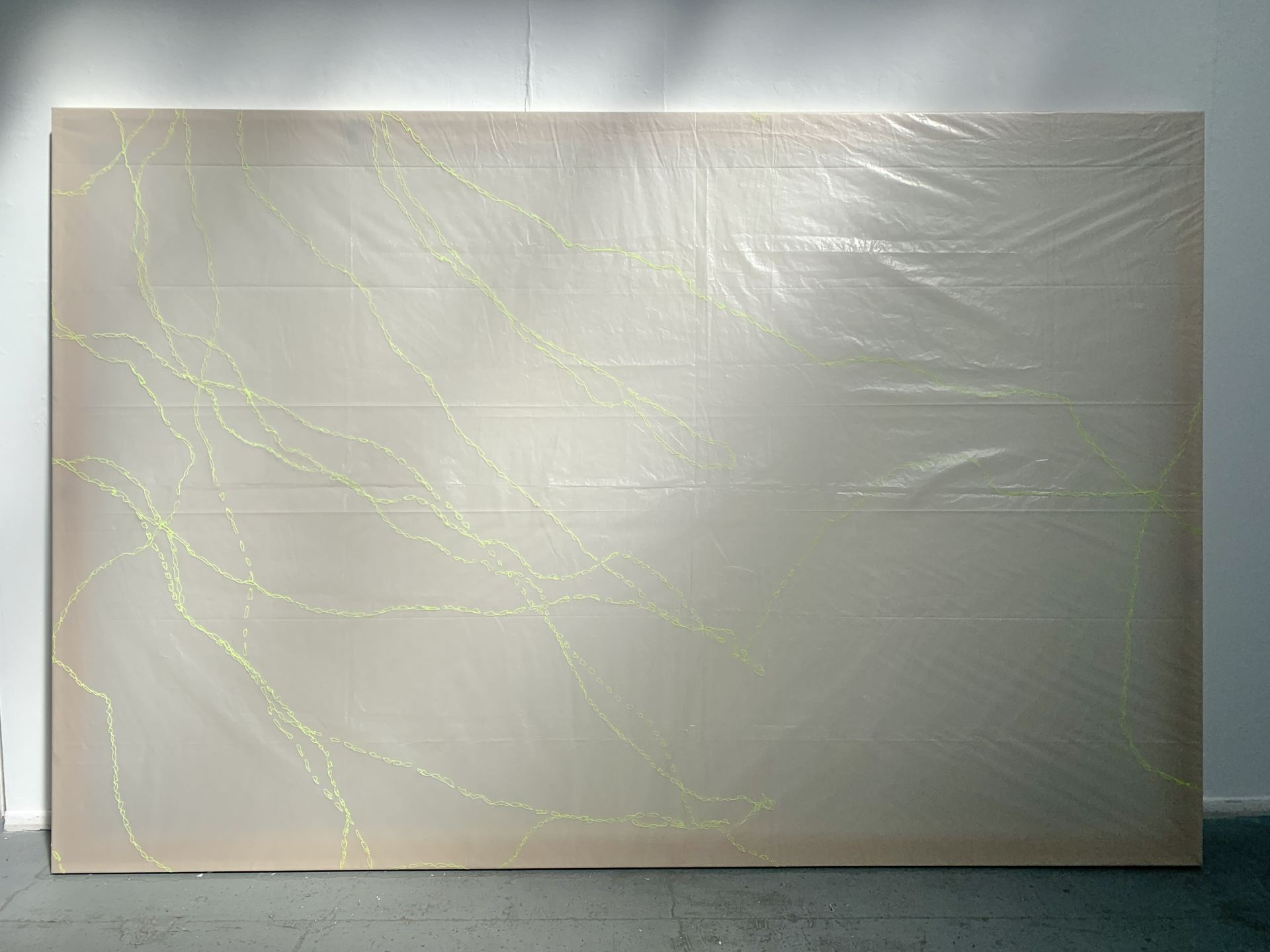 A polyethylene dust sheet is used as a canvas. Yellow embroidery runs across its surface.