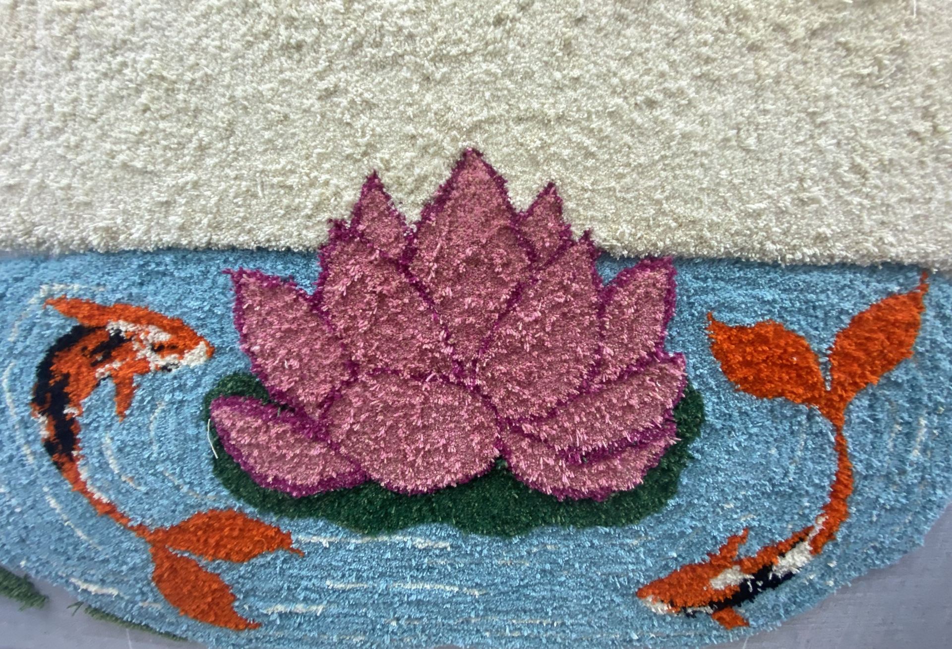 A tufted image of a tufted flower on a body of water, being circled by two orange fish.