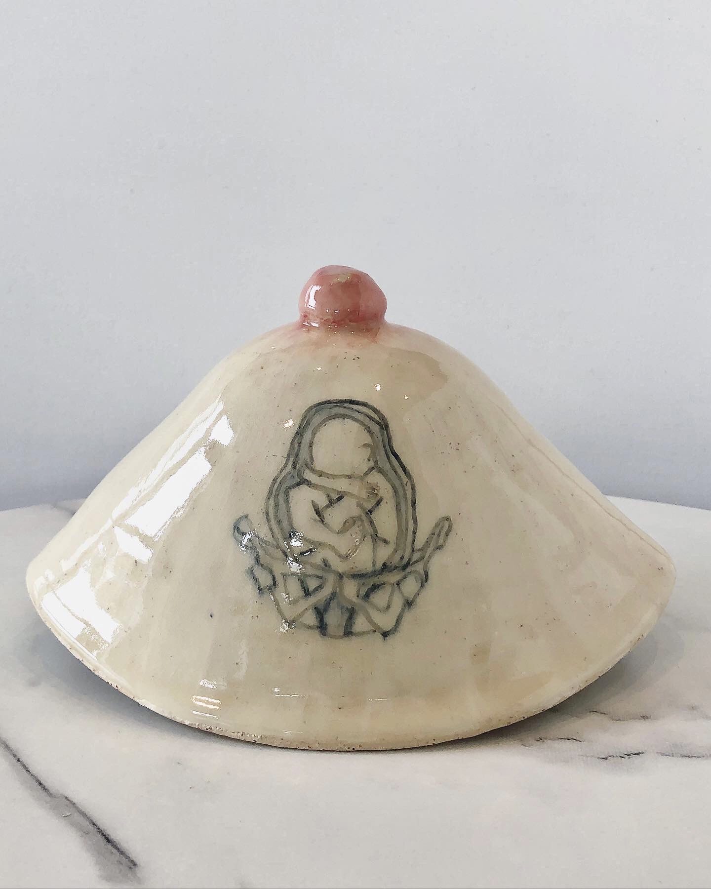 A ceramic breast sits on a table.