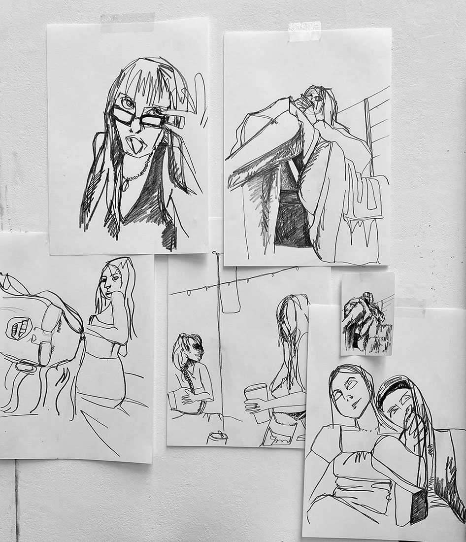 Several pencil drawings of people on paper.