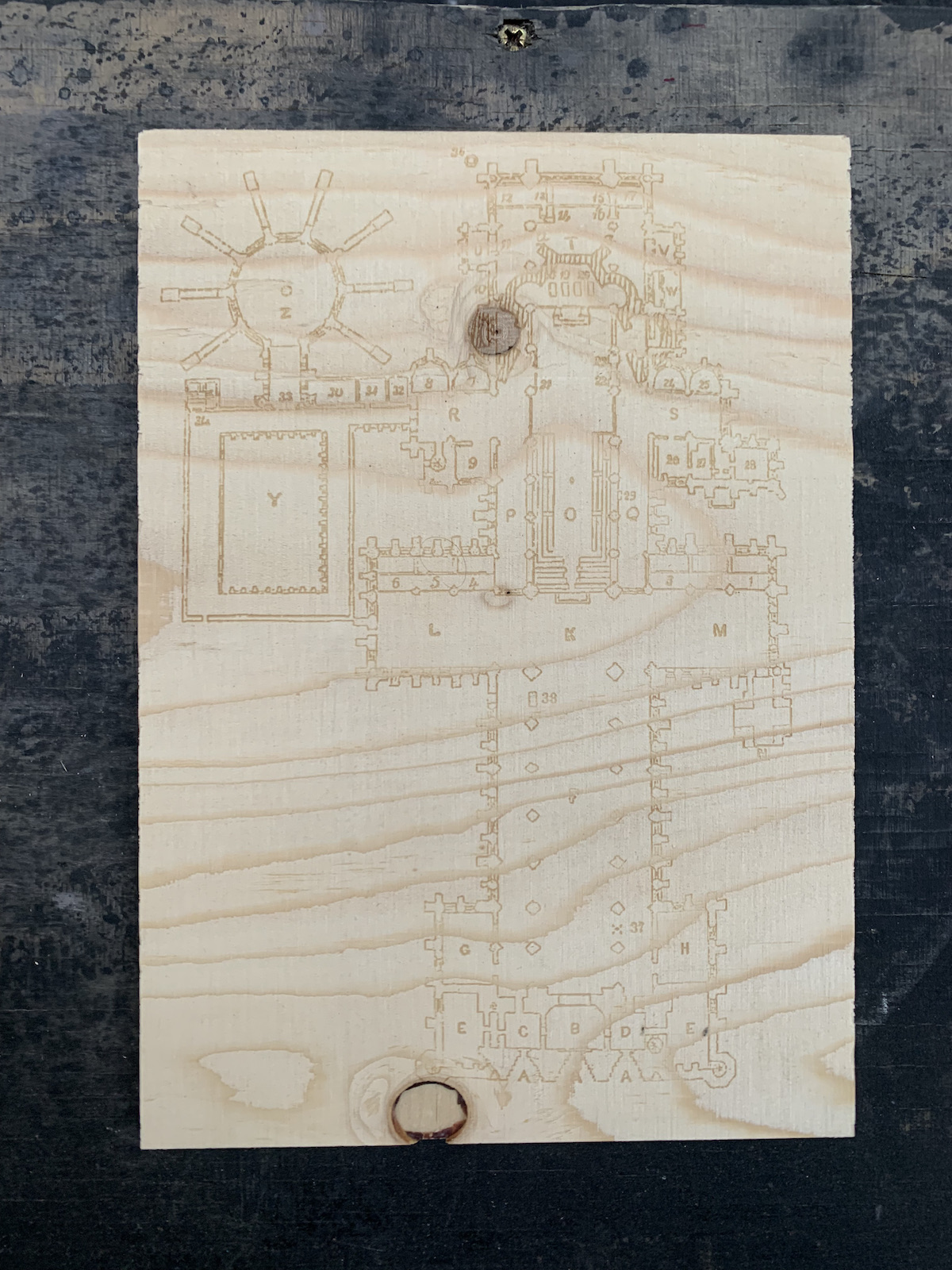 The floorpan for a structure, laser-etched onto plywood.