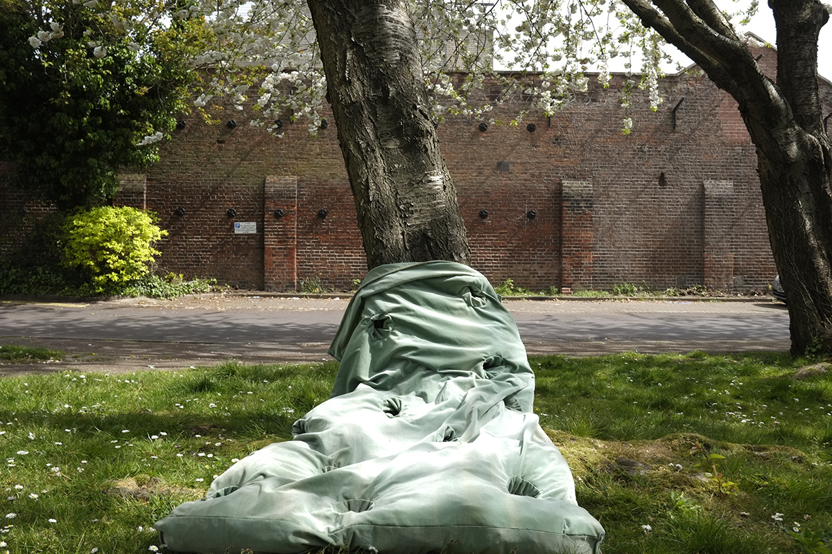 A mint coloured sculpture standing at the foot of a tree.