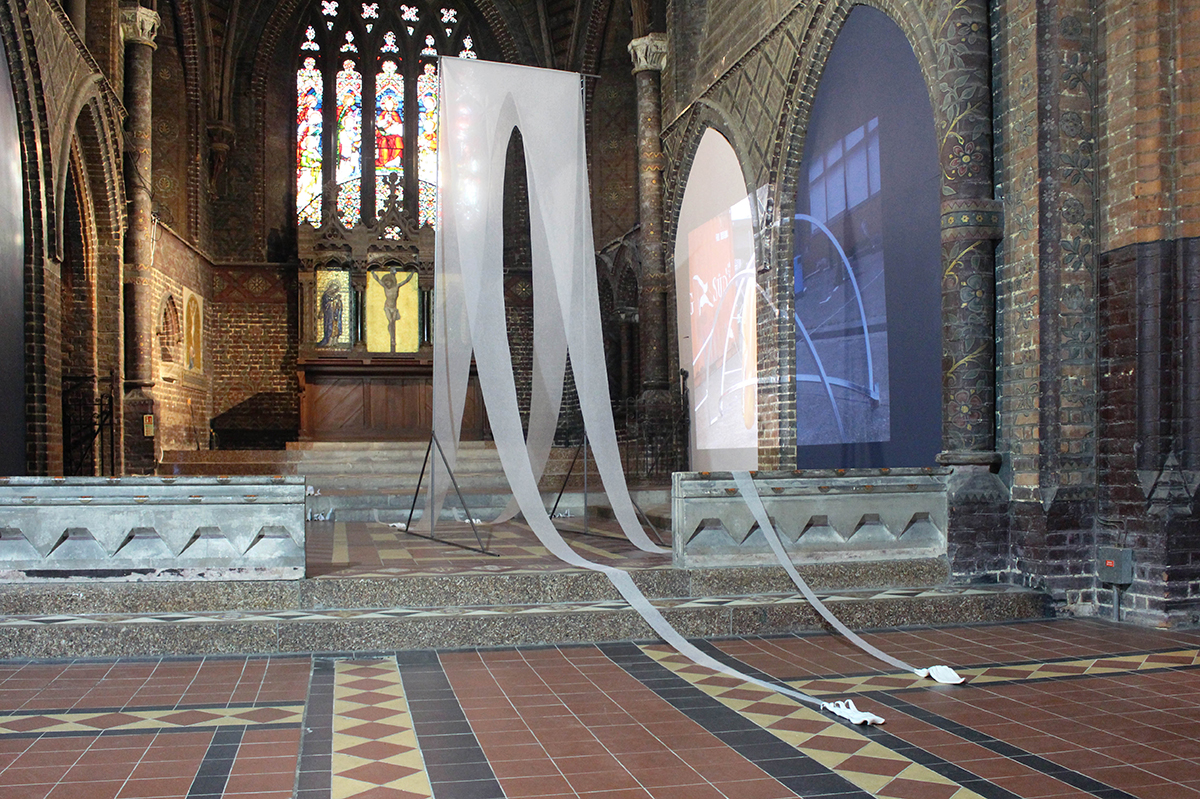 A white sculpture made of light fabric standing in a church.