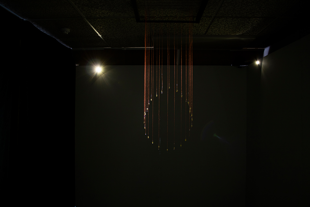 An image of a sculpture made of string against a black background.