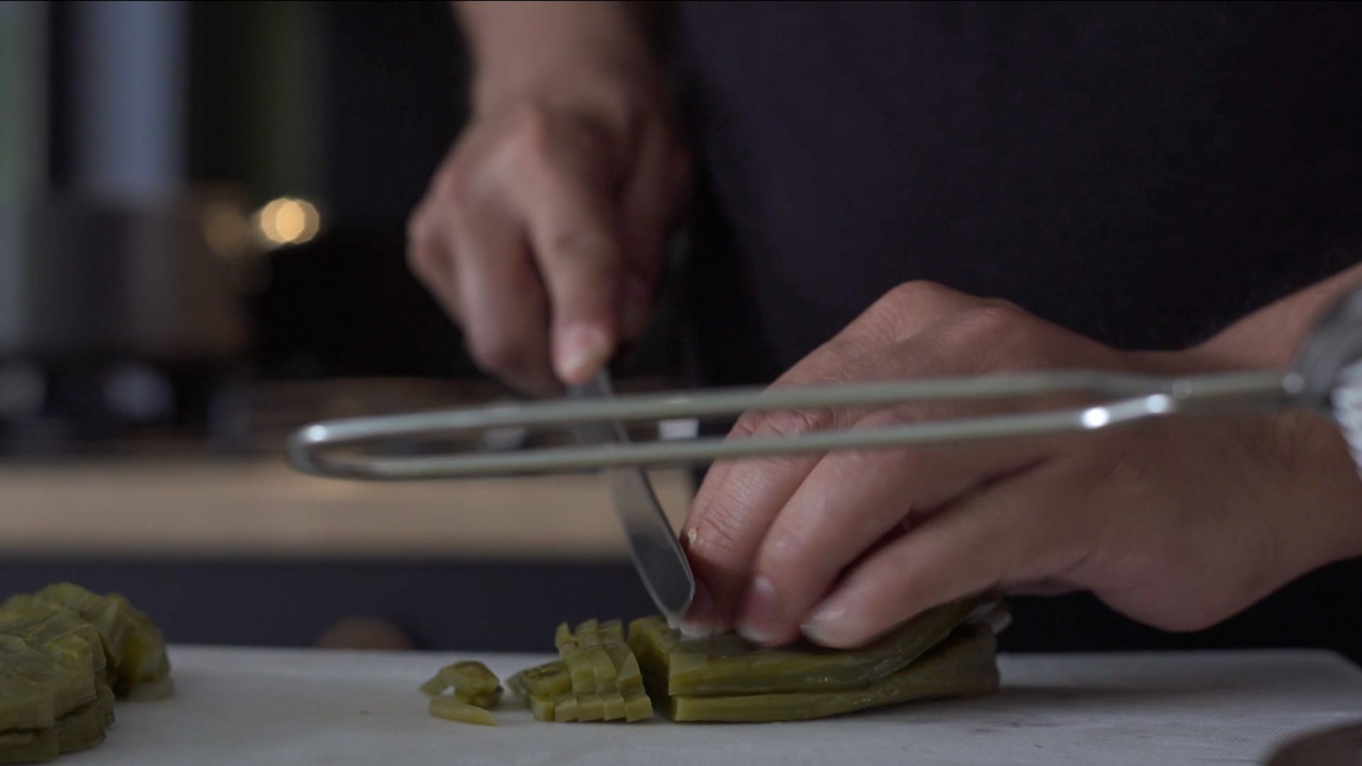 A shot of hands chopping vegetables.