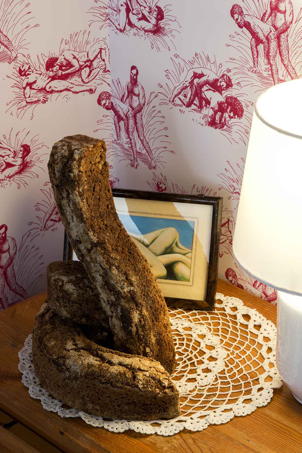 An image of a phallic loaf of bread on a wooden table.