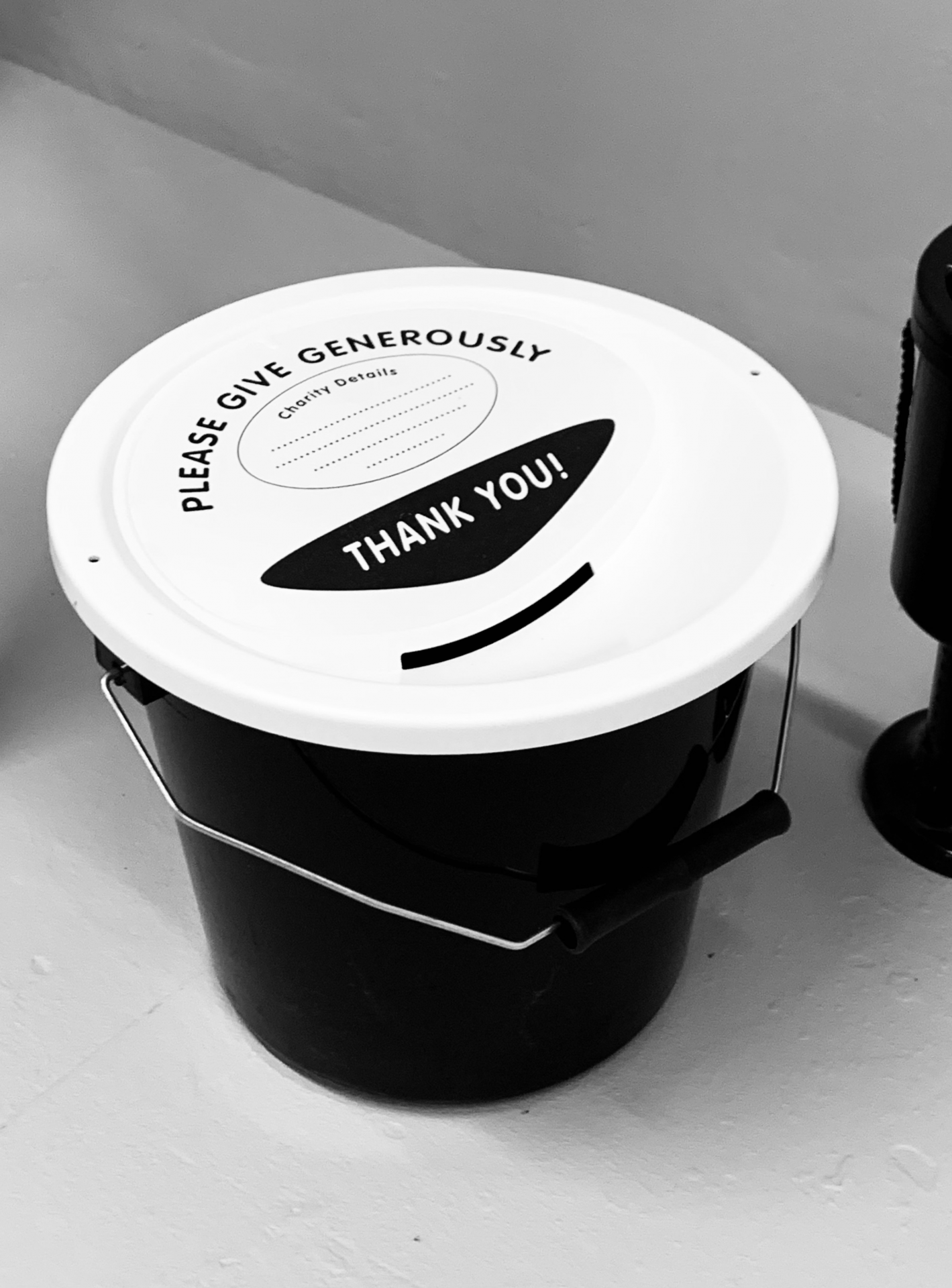 A photo of a black charity donations bucket.