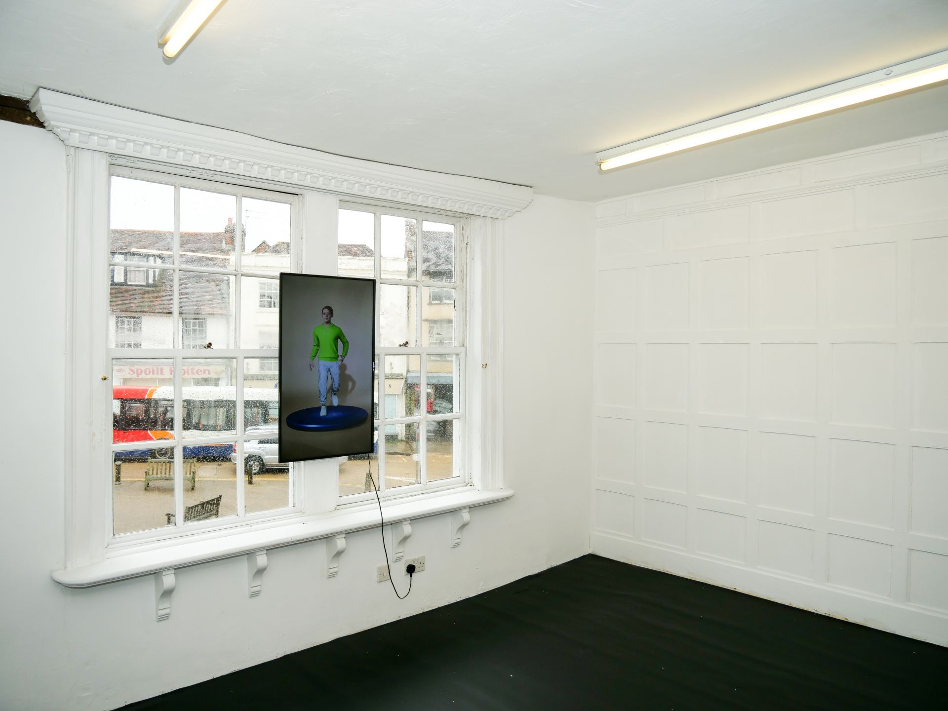 An image of an installation with a screen in a white room.