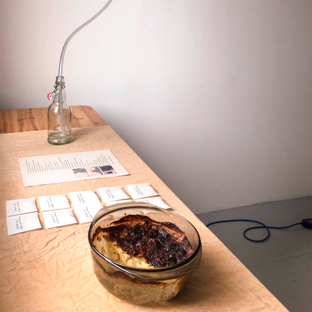 A photo of some food in a dish, on a wooden table with some paper.