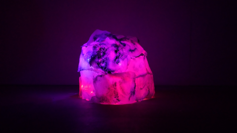 Images of a video installation under a pink light.