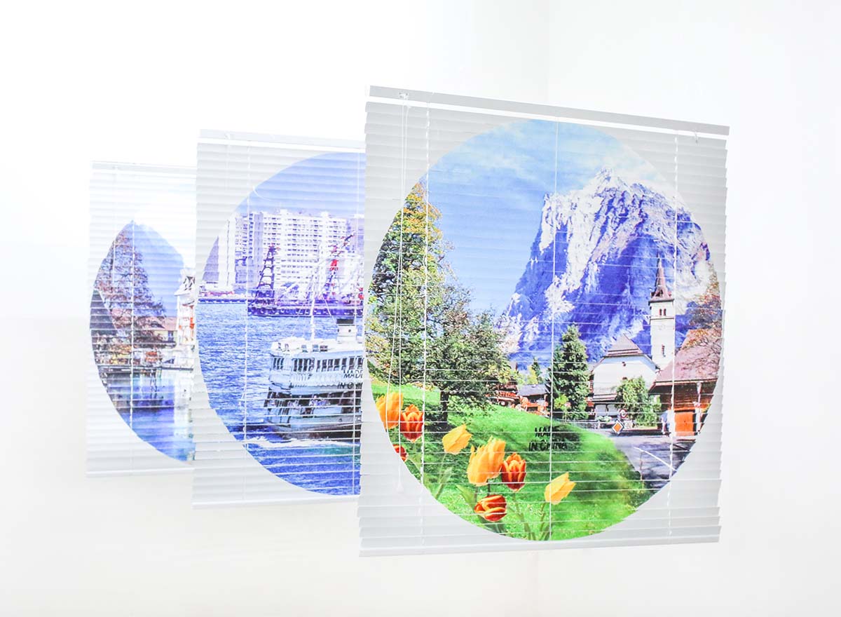 An image of three white blinds with touristic images of Chinese monuments printed onto them.