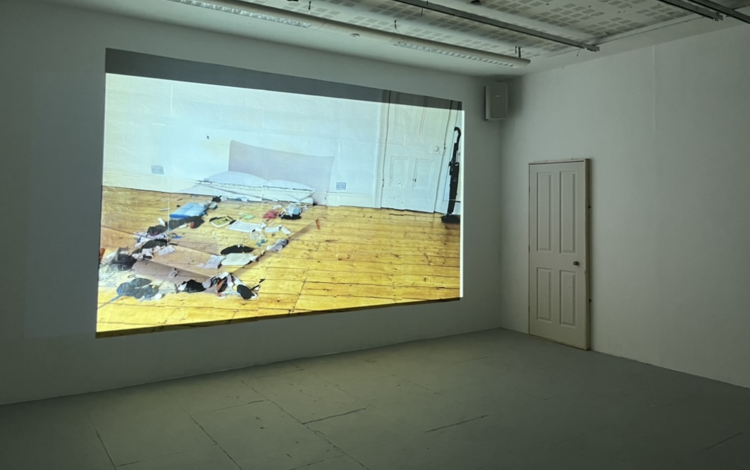 A 4-metre image constructed on the wall, layered with a still projection of an ikea bed, and a door mounted to the wall opening onto an image of multiple identical doors opening in on eachother.