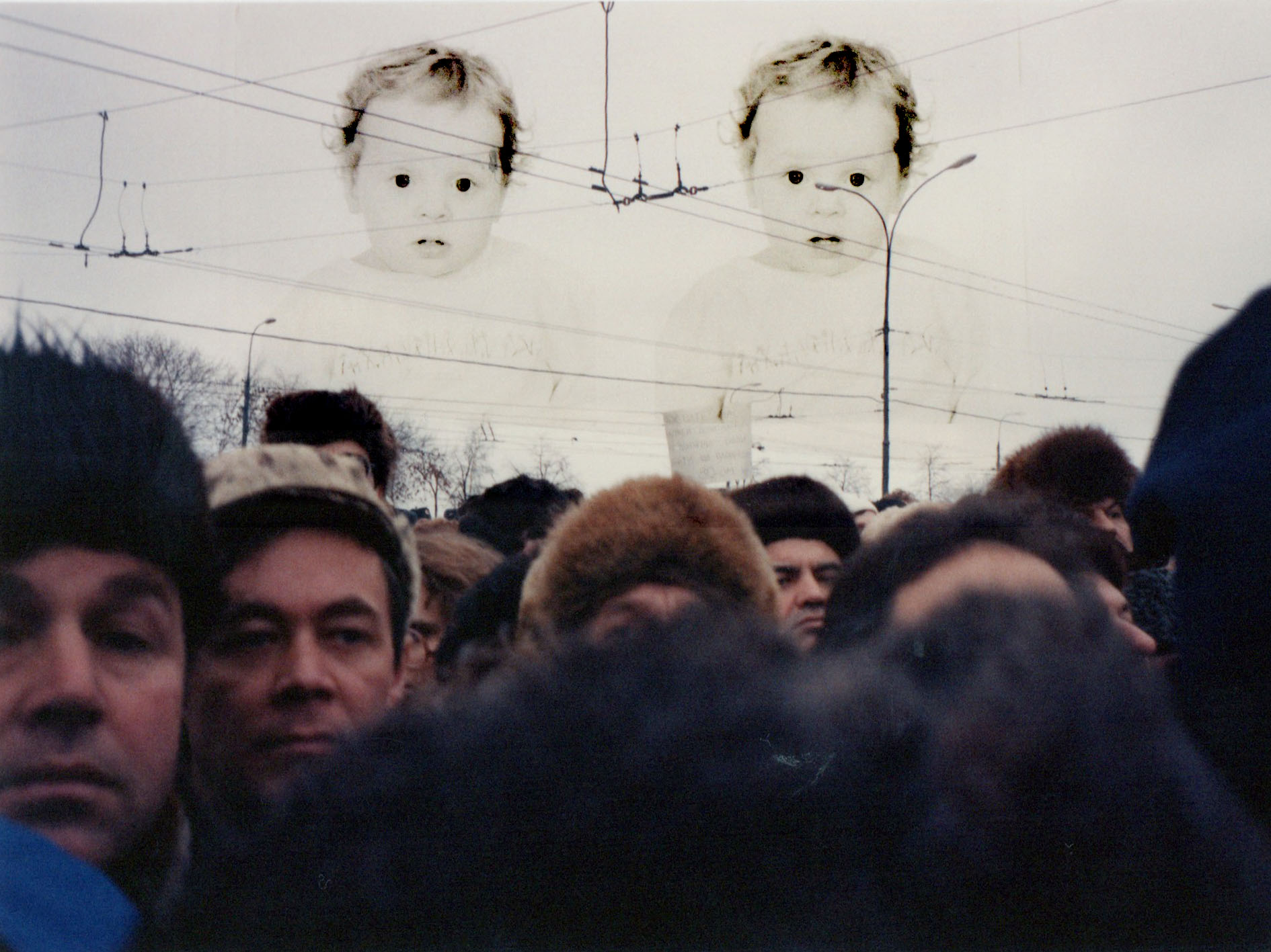 A photoshop collage of a family photo, superimposed over an image of a crowd.