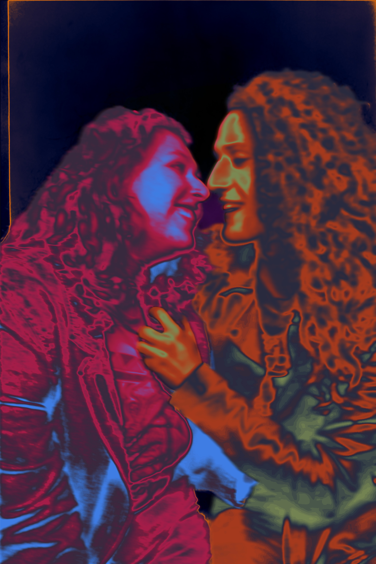 A photograph of a couple smiling and embracing before a kiss, edited so that one figure is entirely blue, pink and purple, and the other is yellow, orange, green and purple, on a dark blue background.
