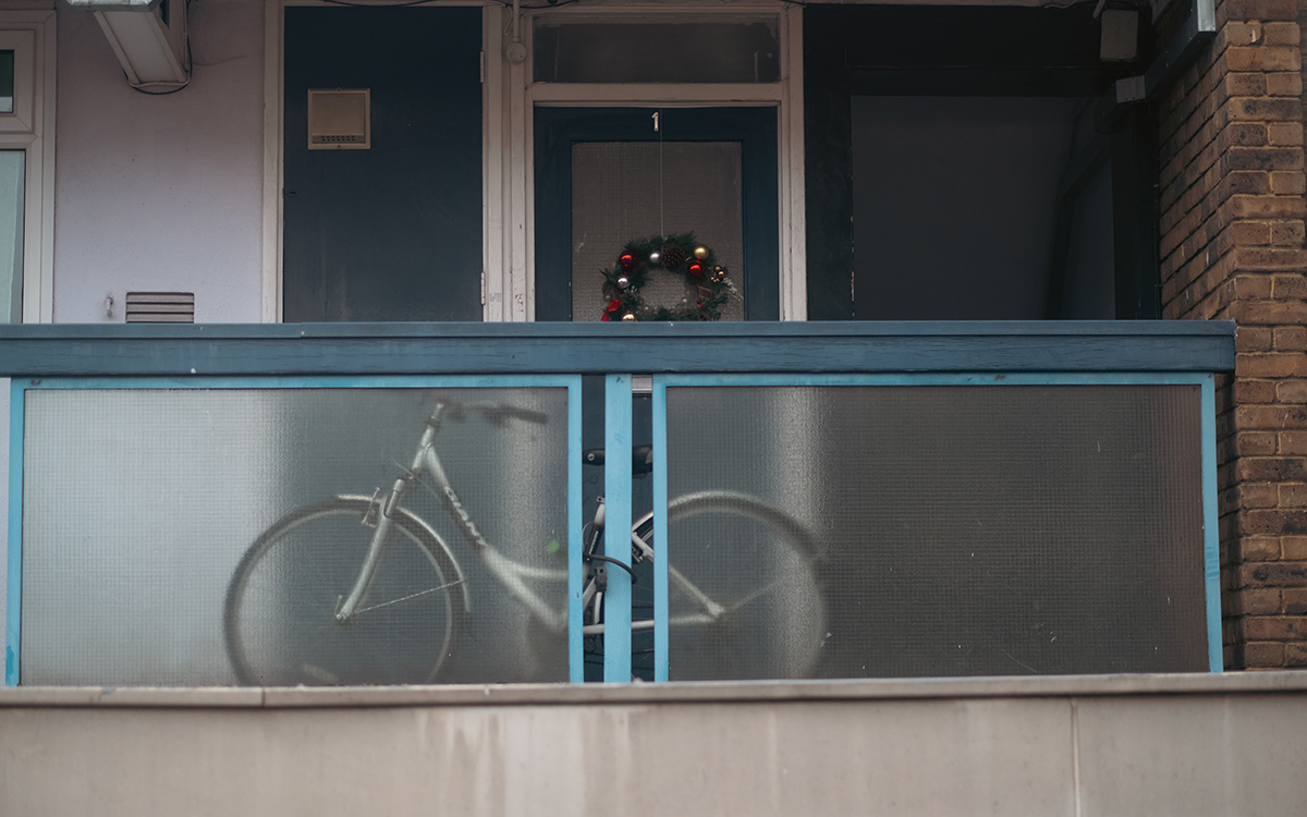 An image of a balcony with a white bike on it.