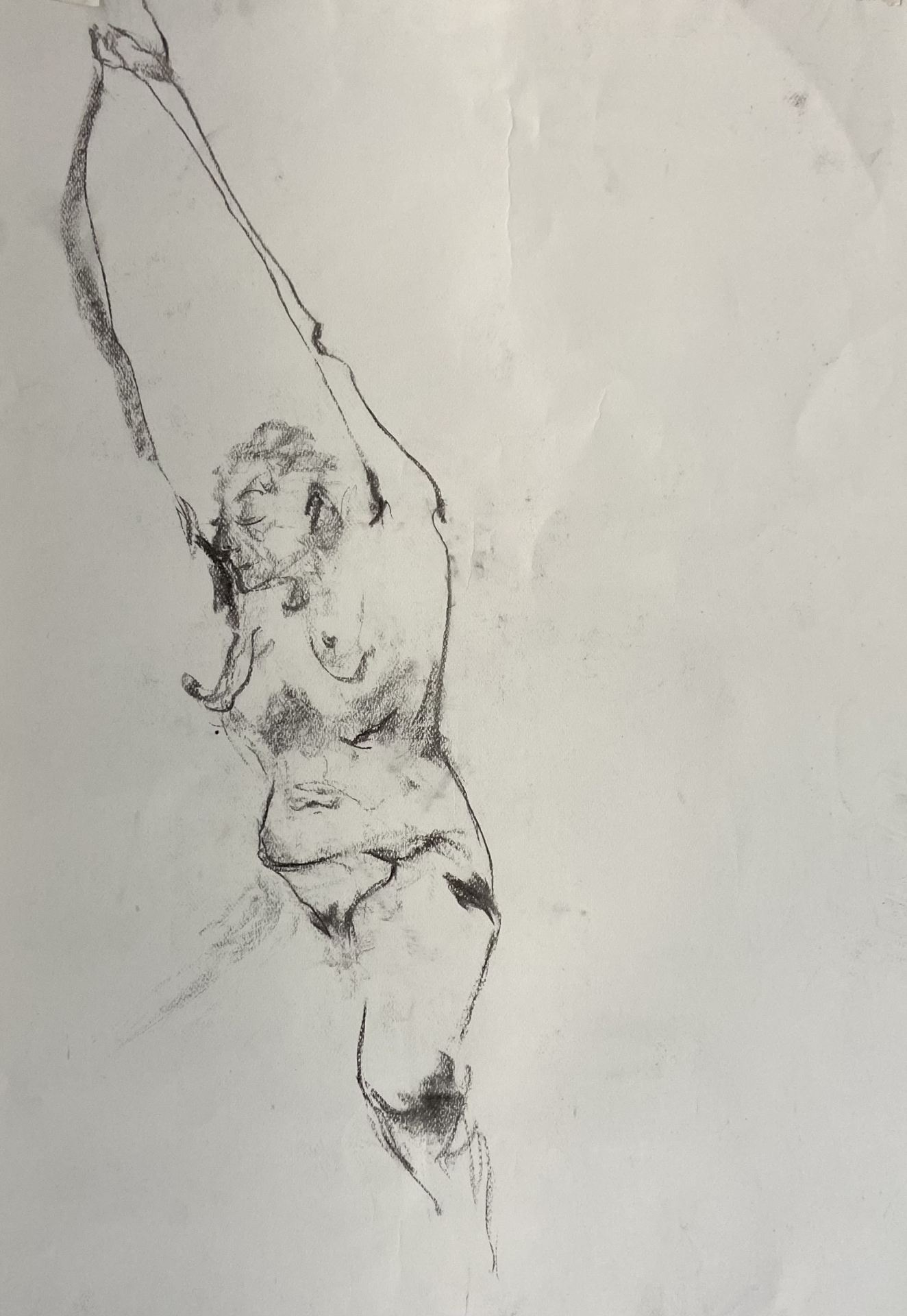 An abstract charcoal drawing of a person on white paper.