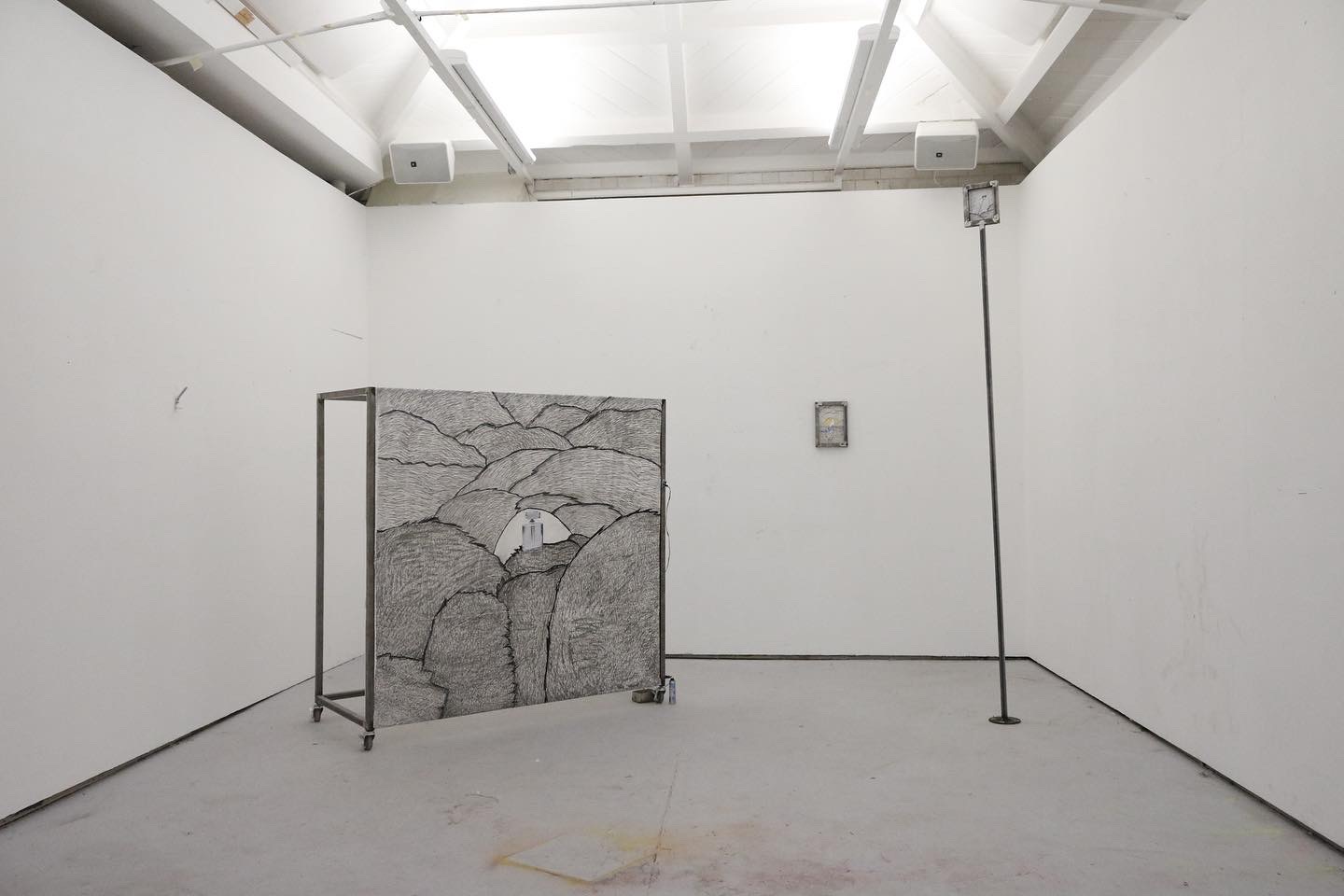 3 metal sculptures framing drawings in a white room. The largest
one (on wheels) includes a stock photo and has a motion sensor
attached to it, linked to an Arduino which sprays 'Impulse - tease'- (£1 body spray) on viewers.