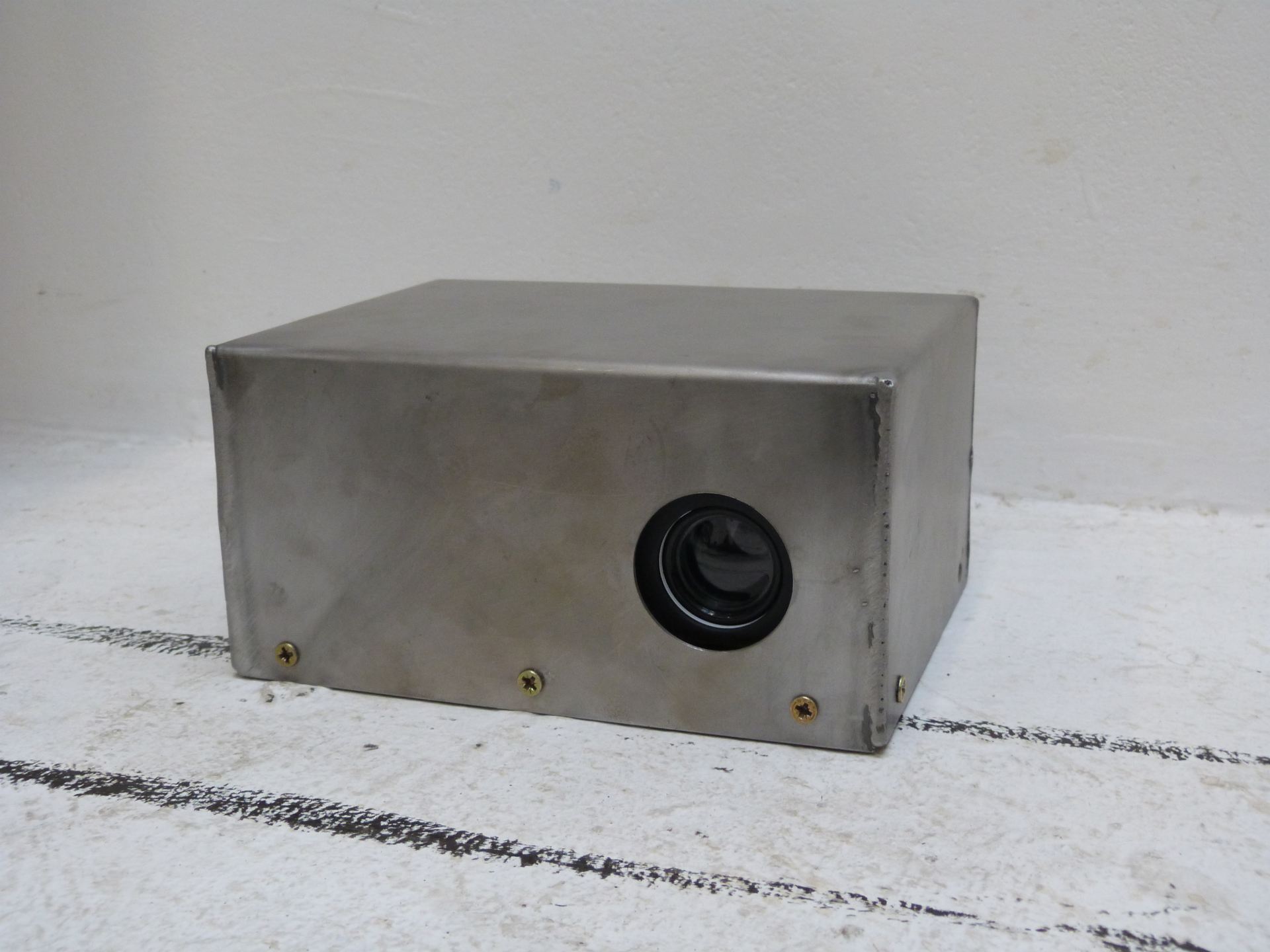 A metal box designed for holding a projector set against a white background.