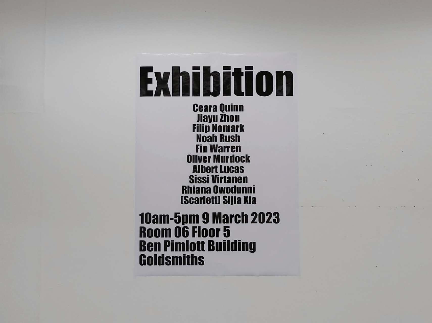 An exhibition poster containing several of the artist's course-mates' names in black, on a white A4 page, hung on a white wall.