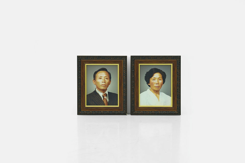 An imagee depicting two portraits of the Artist's grandparents in ornate frames, side by side.