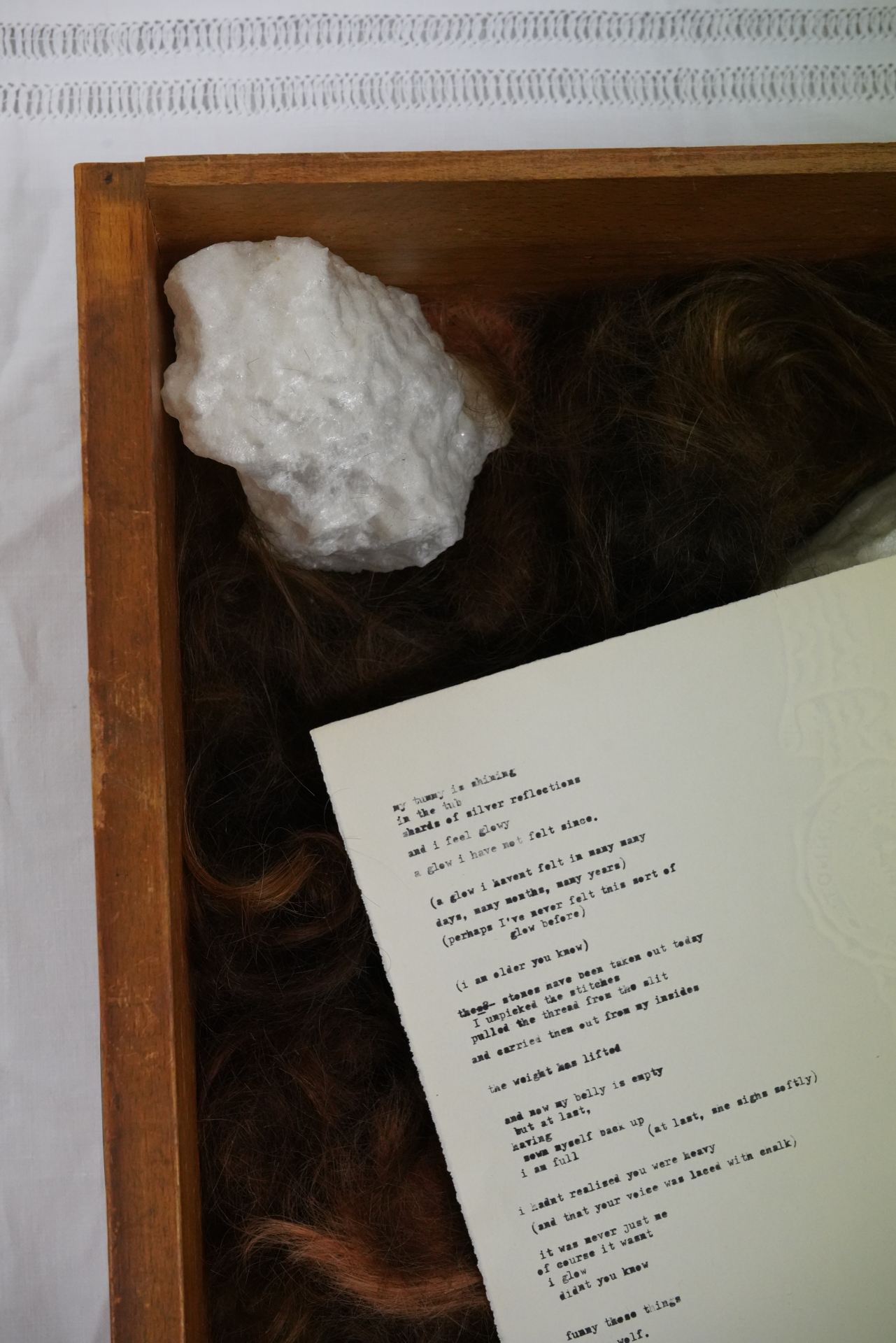 A bird's eye view of a box containing 3D printed stones and a handwritten note.