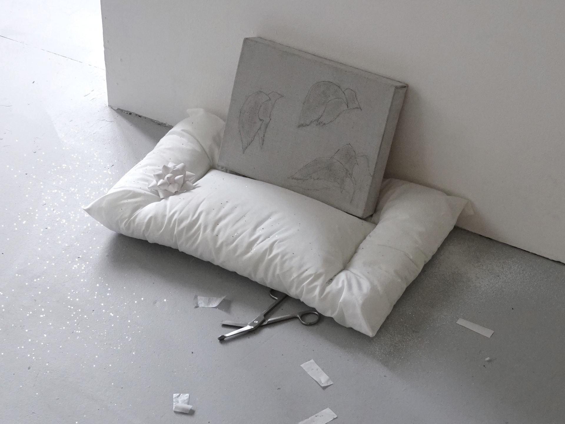 An image of a grey, cast object on a white pillow.