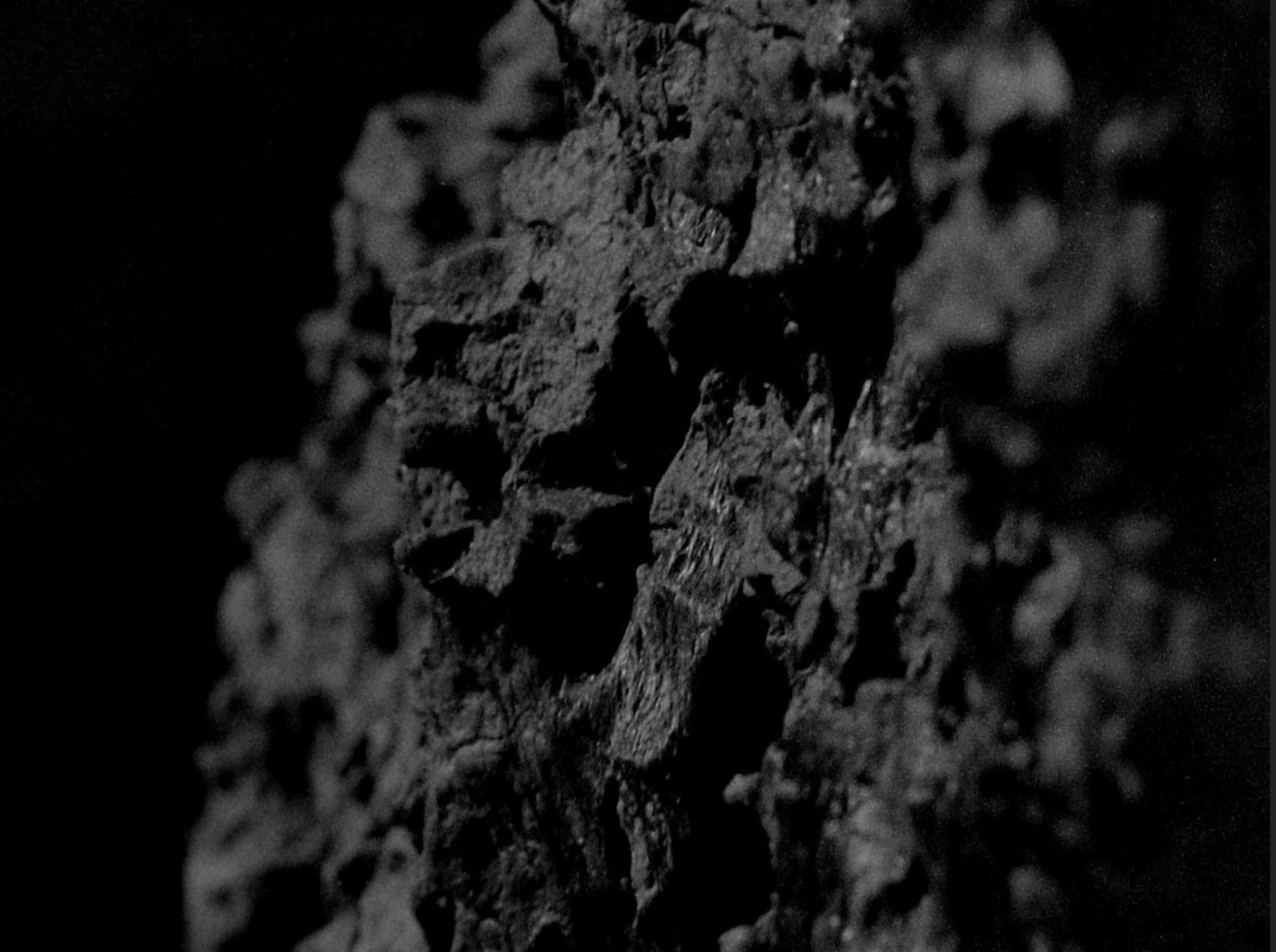 A close-up film still of the texture of a rocky surface.
