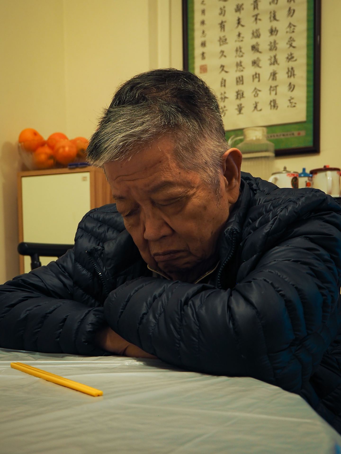 A photography of my grandfather sitting around the dining table, falling asleep.