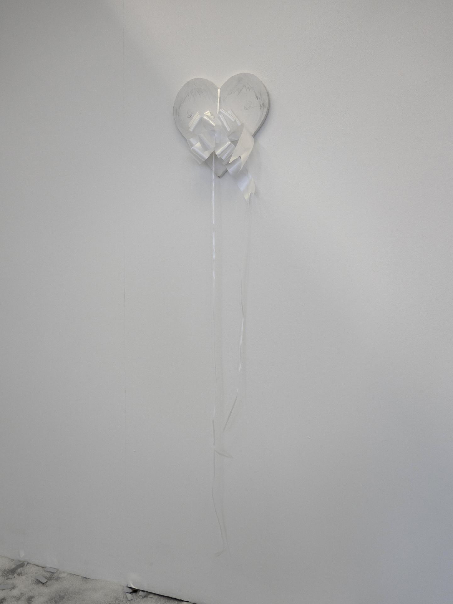 An image of a white object hung on a white wall.