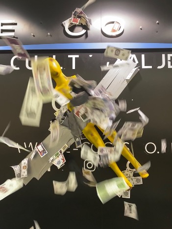 An image of a spinning yellow armature that seems to be dispensing dollar bills.
