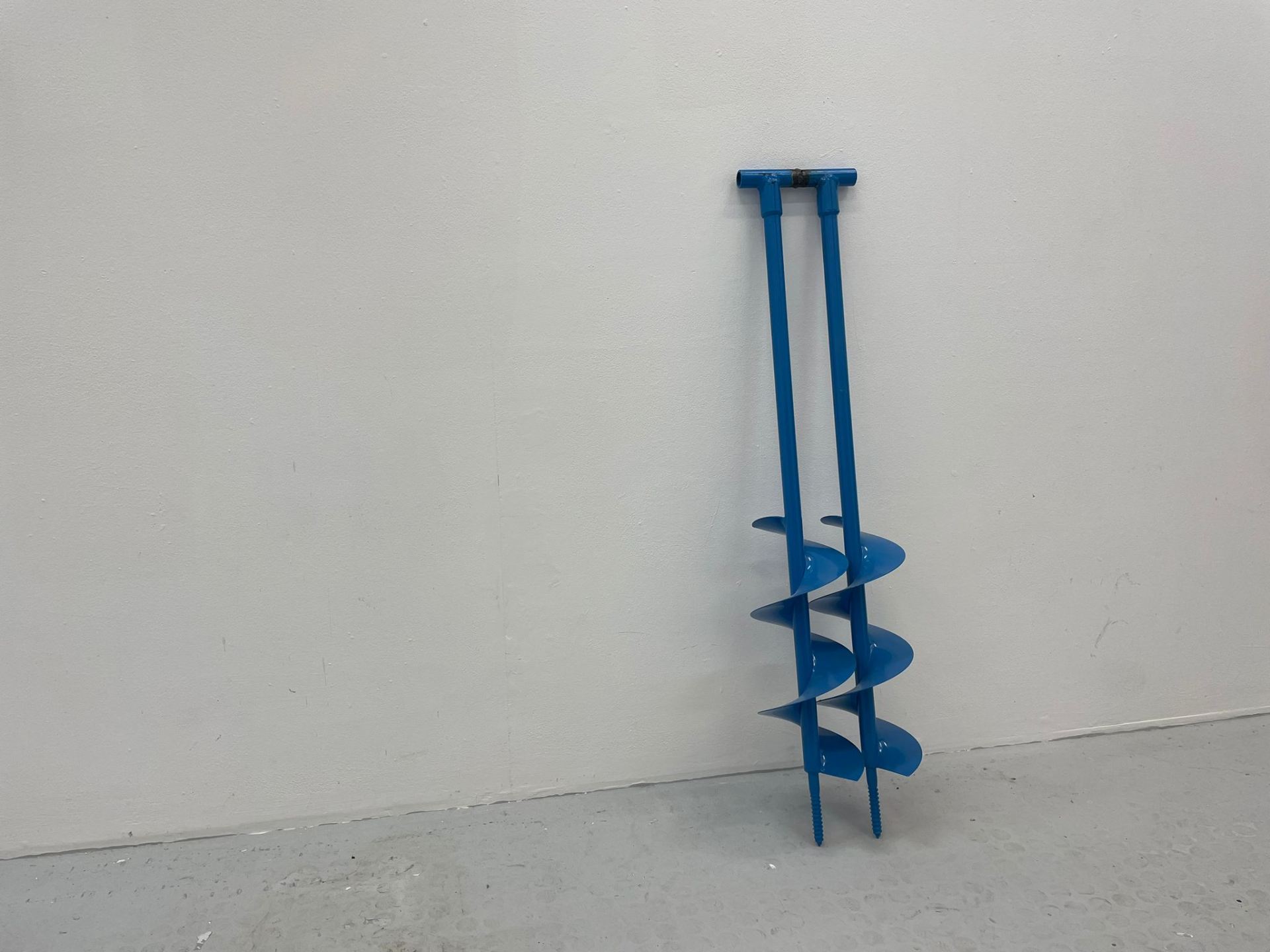 An image of two blue Augers welded together and standing side by side.