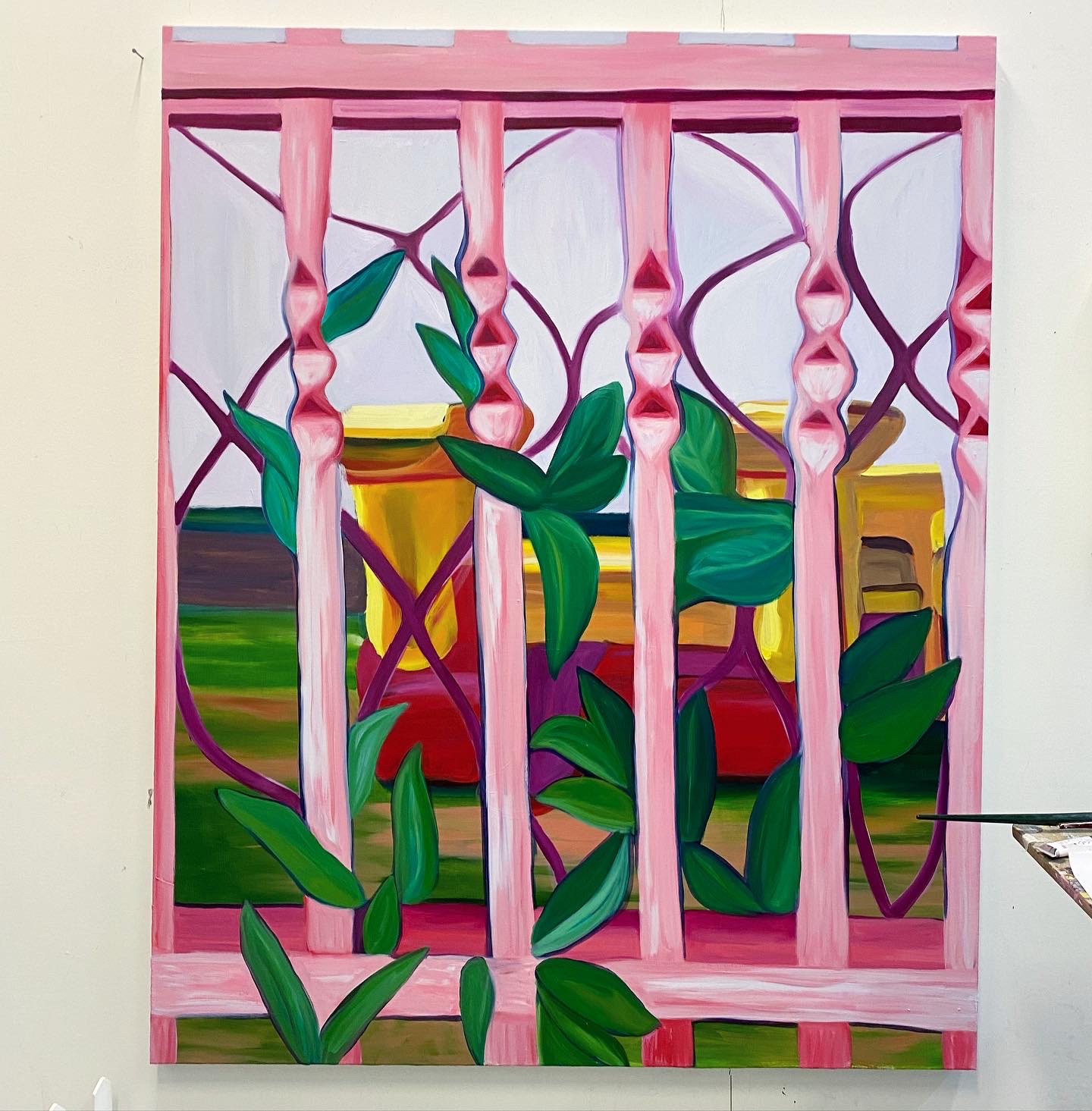 A painting of a yellow bouncy castle, seen through the pink bars of a fence.