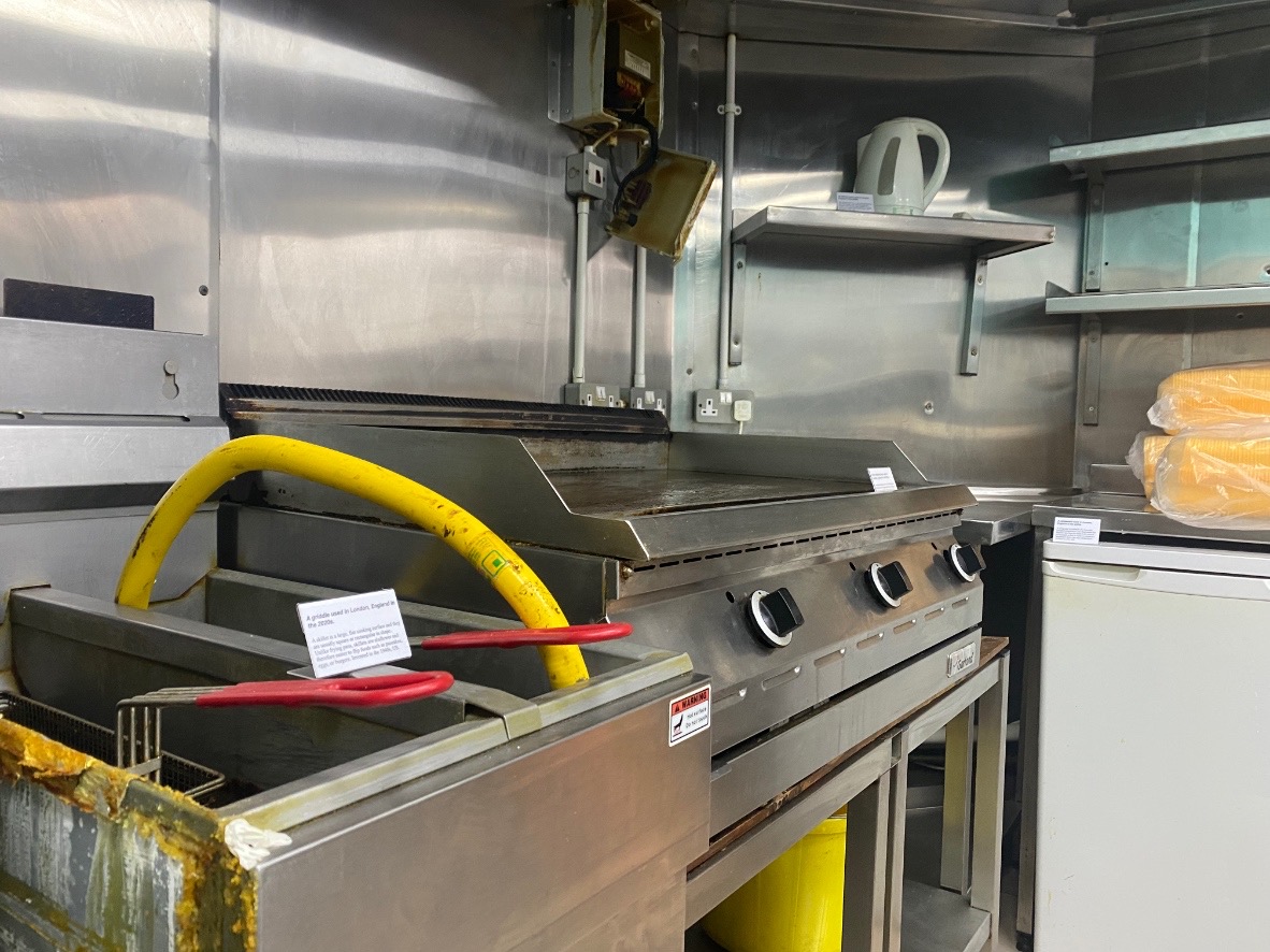 An image of a deep fat frier and an oven, labelled with small white signs.