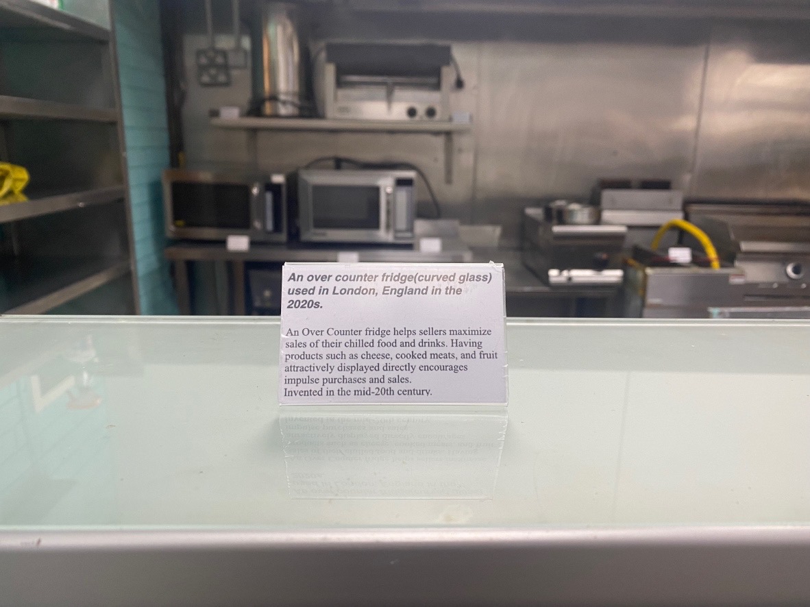 An image of a small white  sign on a glass counter top.