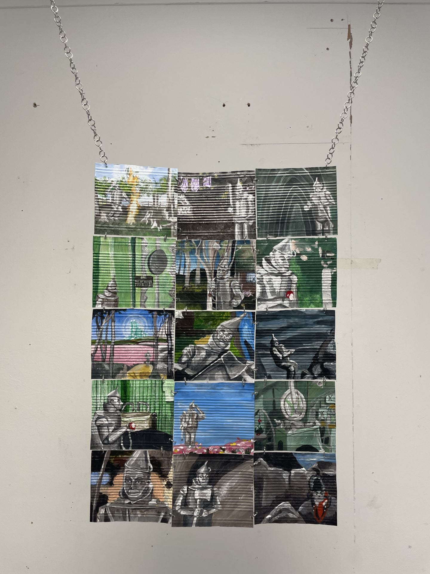 A photo of a hanging piece with several images of the Tinman from The Wizard of Oz. 