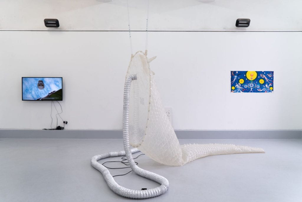 A group exhibition at Lewisham Arthouse with a plastic sculpture, a screen showing a film and a painting. 