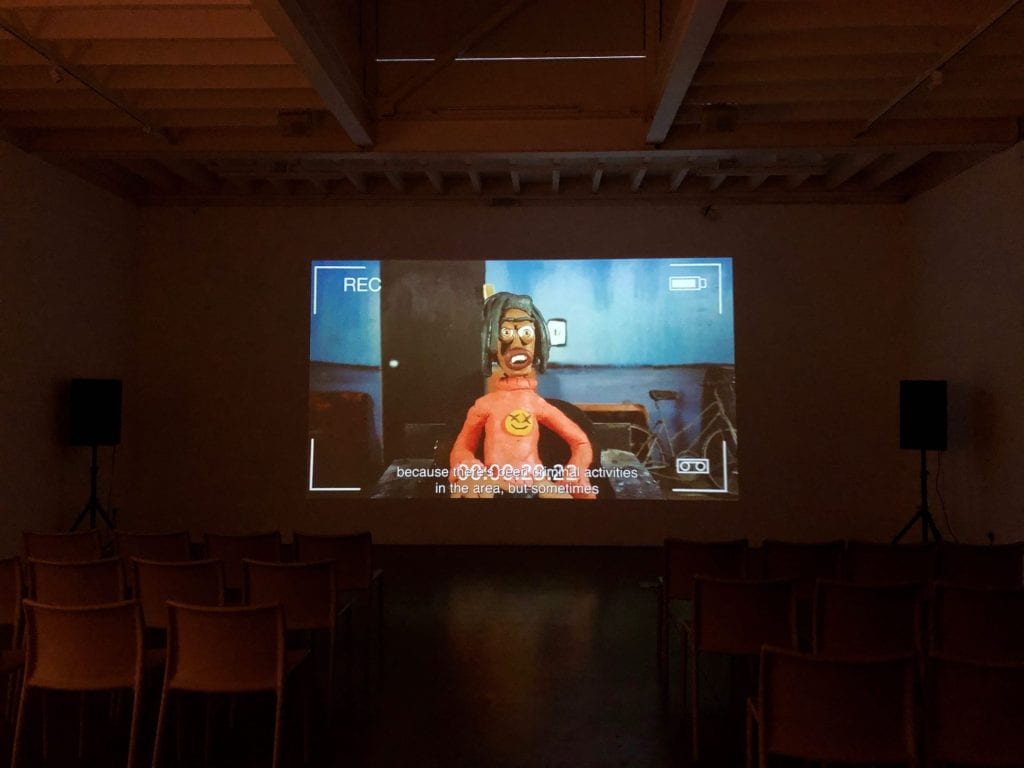 Screening of Djofray Makumbu's film at South London Gallery, a still shows a clay model speaking about police discrimination.