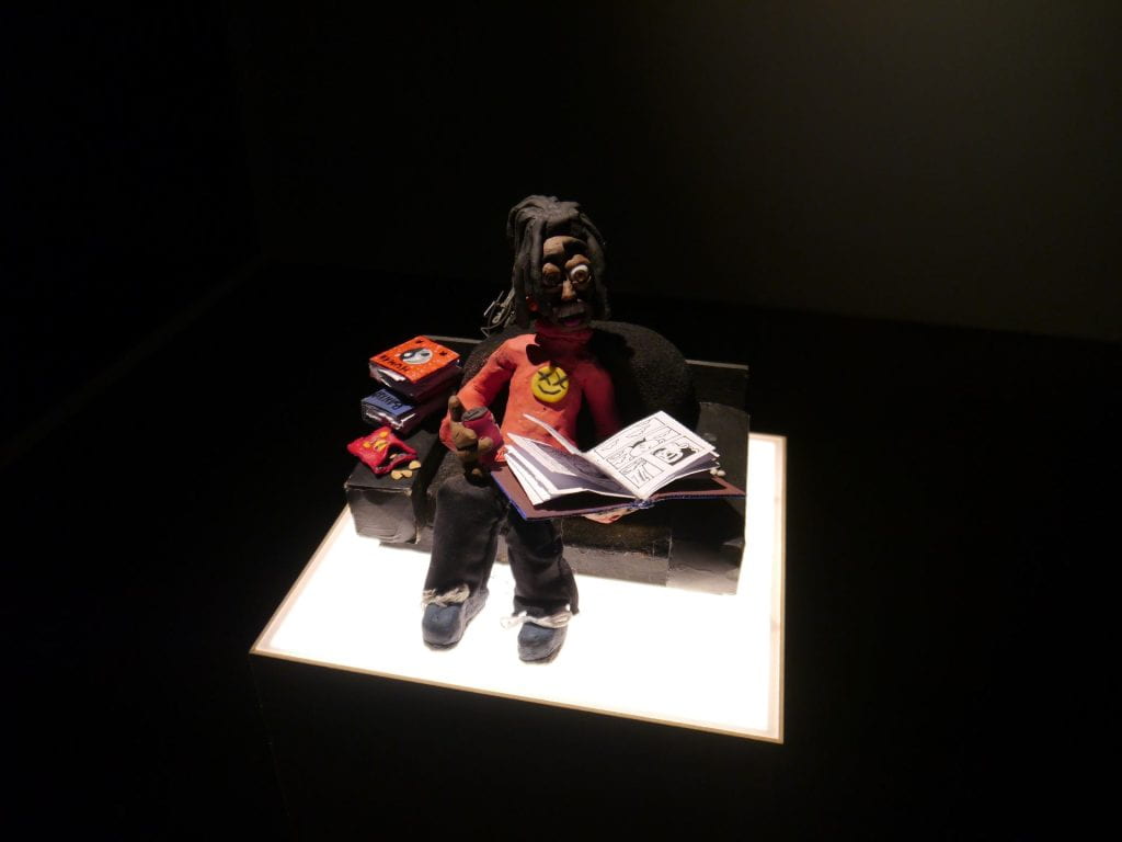 Djofray Makumbu's exhibition Hello Mr. Officer at South London Gallery, November 2021, showing a clay model reading a comic book in an armchair. 