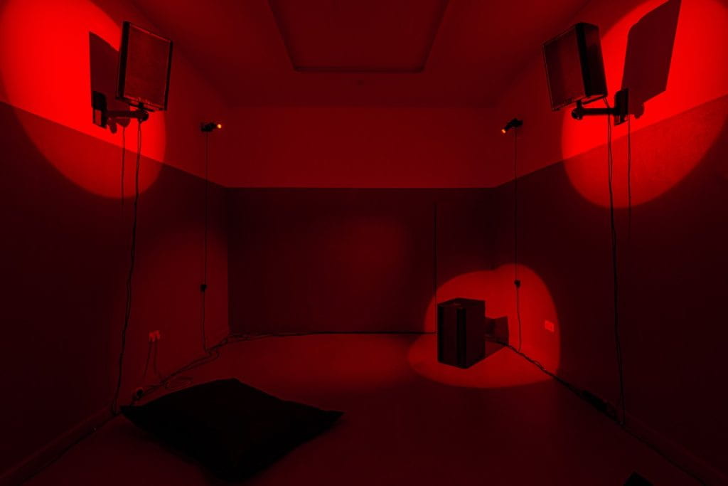 Tiffany Wellington's solo exhibition Grey Area at Studio Chapple, a red room lit with spotlights.