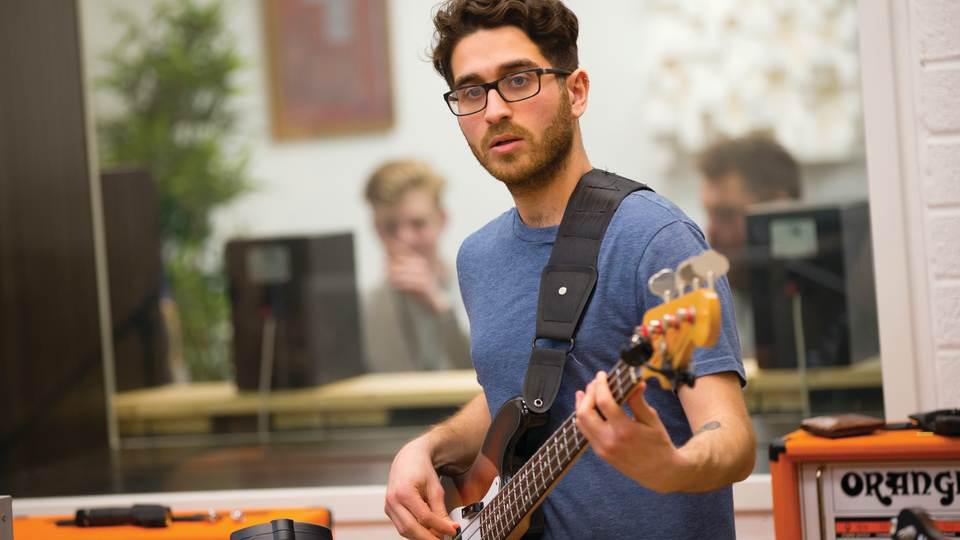 A musician playing bass guitar in Goldsmiths Music Studio, Studio 1