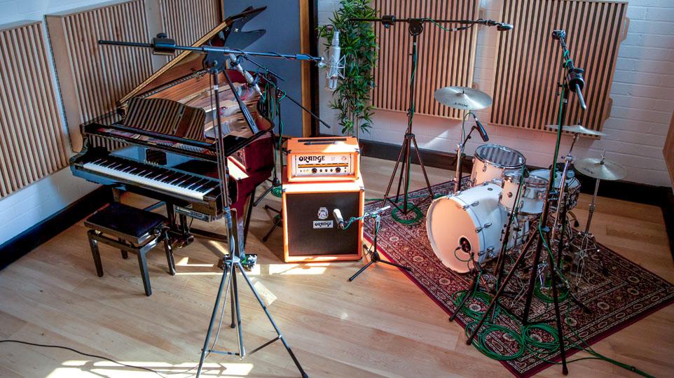 A grand piano, a guitar amp and a drum kit in Goldsmiths Music Studios Studio 1. All instruments have mics placed in front of them 