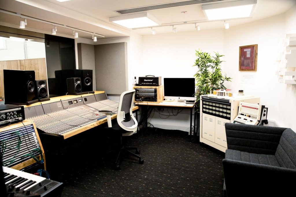 Goldsmiths Music Studio control room containing a Calrec console, a 24 track machine and various other studio equipment