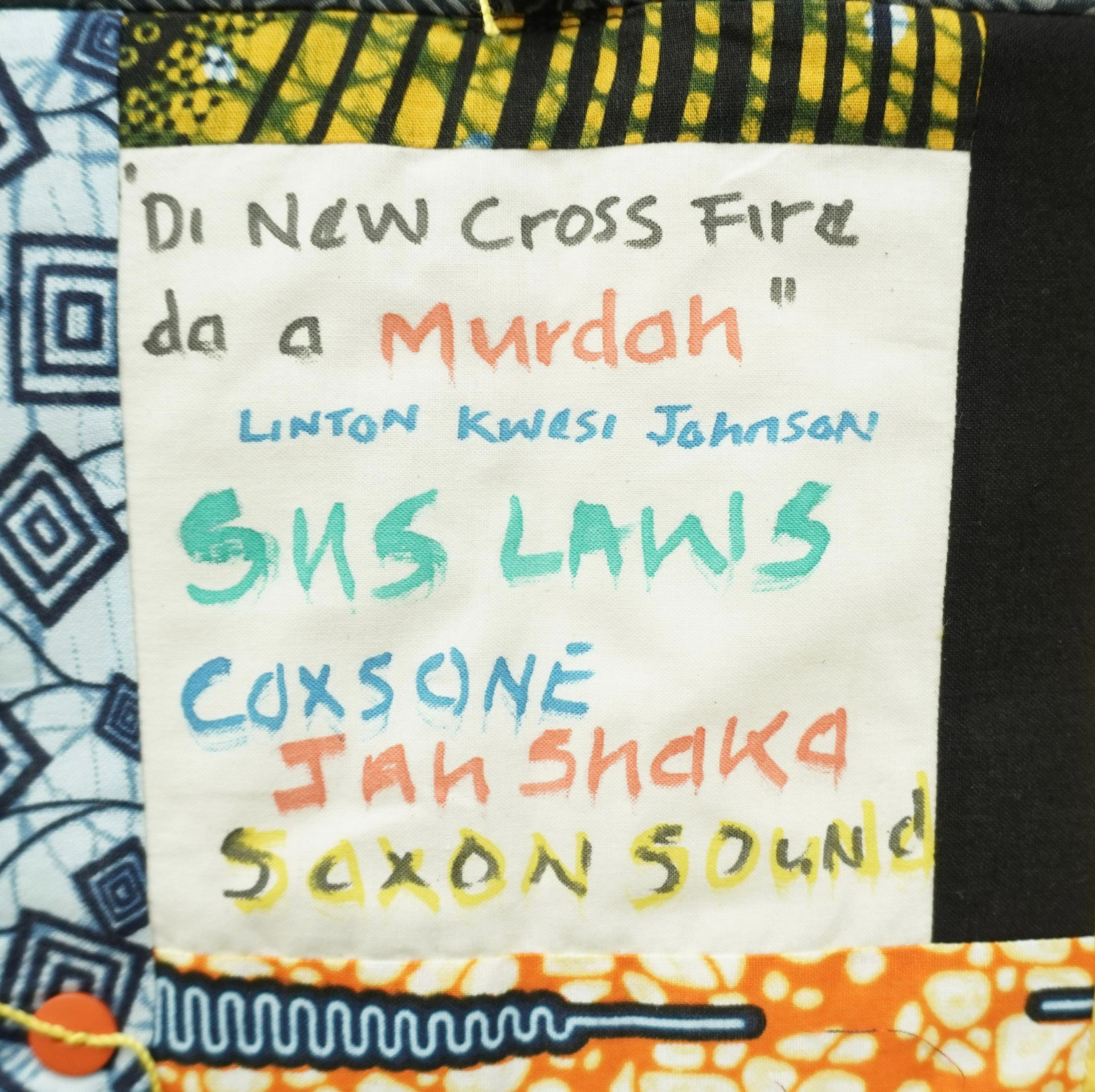 Commemorative quilt. Text reads, 'Di New Cross Fire da a murdah, Linton Kwesi Johnson, SNS Laws, Coxsone, Jah Shaka, Saxon Sound'